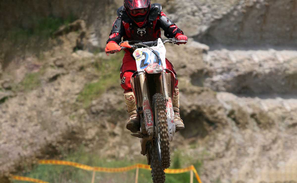 Motociclista saltando un obstáculo en su moto.